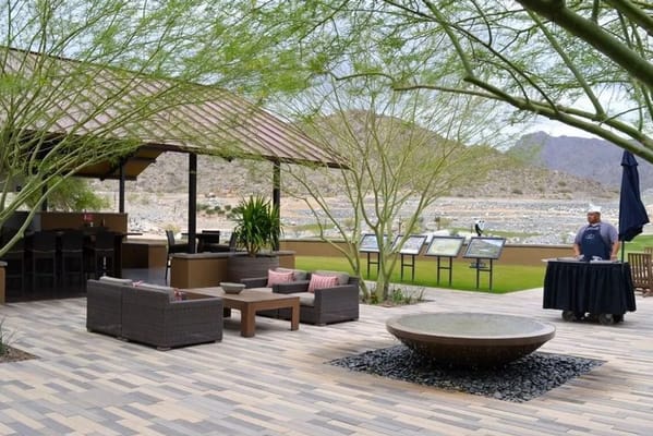 Outdoor seating area with a waiter beside a scenic view