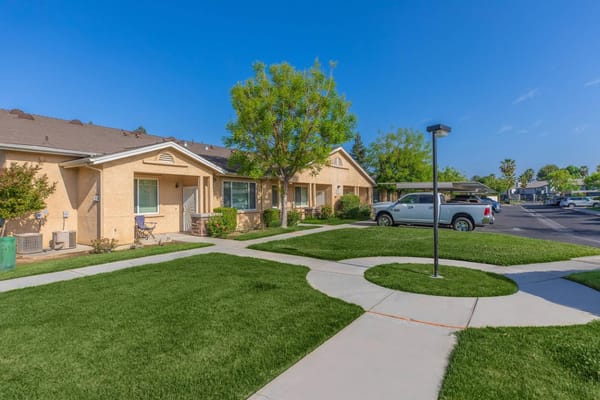 Exterior view of Arbor Faire Senior Apartments with garden area