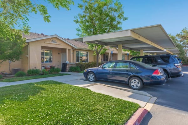 Building exterior with covered parking and greenery