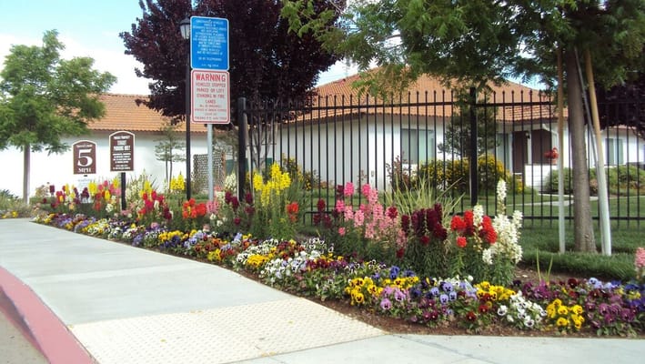 Exterior view of the facility with flowers and signage