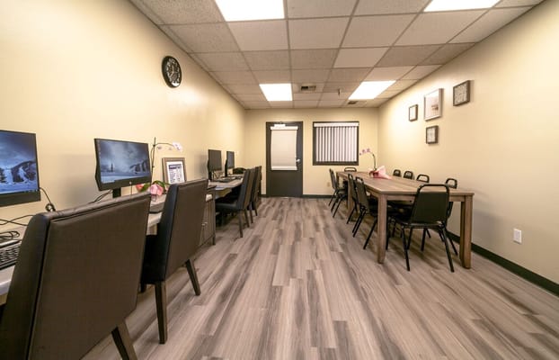 A computer room with desks and seating for activities
