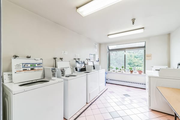 A laundry room with washing machines and a window view