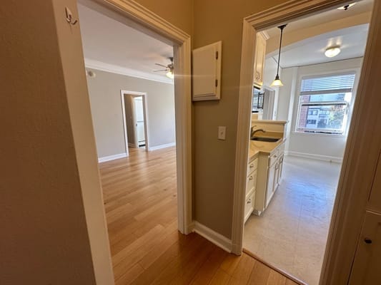 View of hallway leading to a kitchen with natural light.