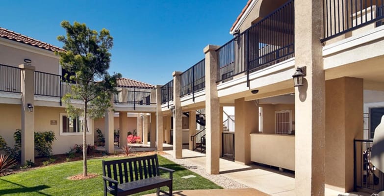 Outdoor courtyard with seating and landscaped area at Villa Anaheim Senior Apartments.