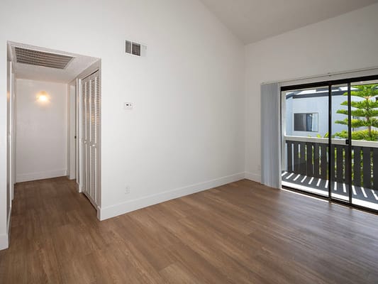 Bright and empty interior room with wood flooring