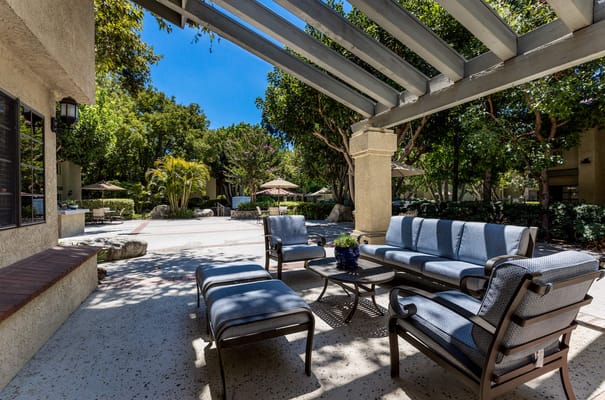 Outdoor seating area with shaded patio and landscaping