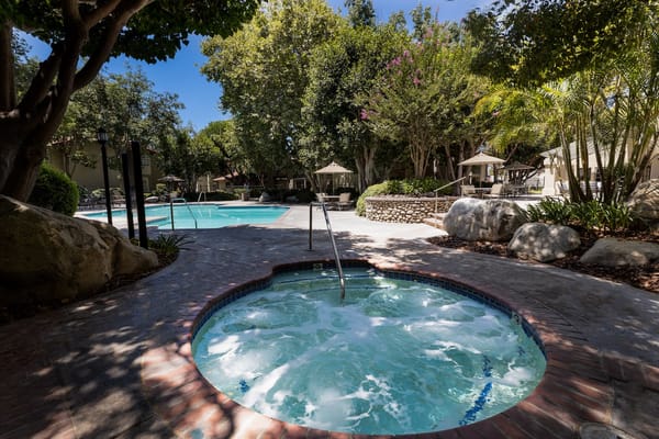 Serene outdoor pool area with jacuzzi and seating