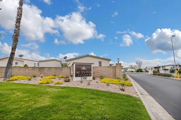 Exterior view of Mission Village entrance sign and landscaping