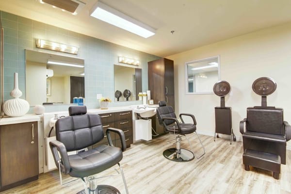 Hair salon area with styling chairs and dryers