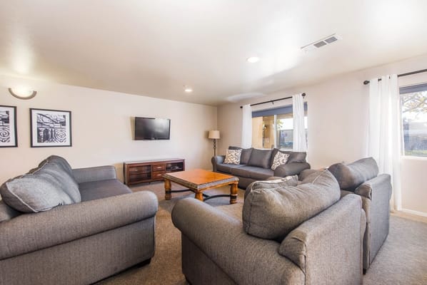 Spacious living room with gray couches and a television