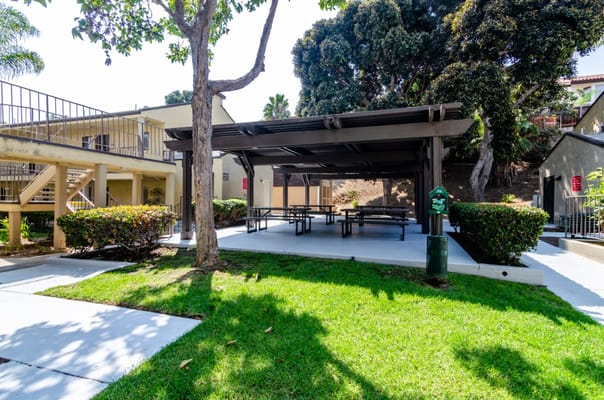 Covered picnic area with benches surrounded by greenery