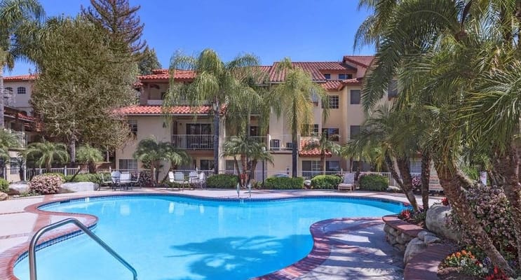 Pool area surrounded by lush landscaping at the facility