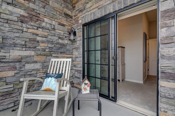 Balcony with a rocking chair and decorative flower pot.
