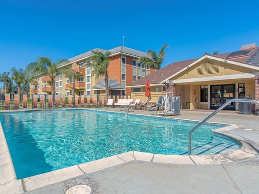 Outdoor pool area with lounge chairs and shade umbrellas