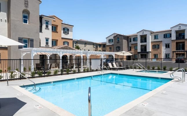 Outdoor pool area with lounge chairs and umbrellas