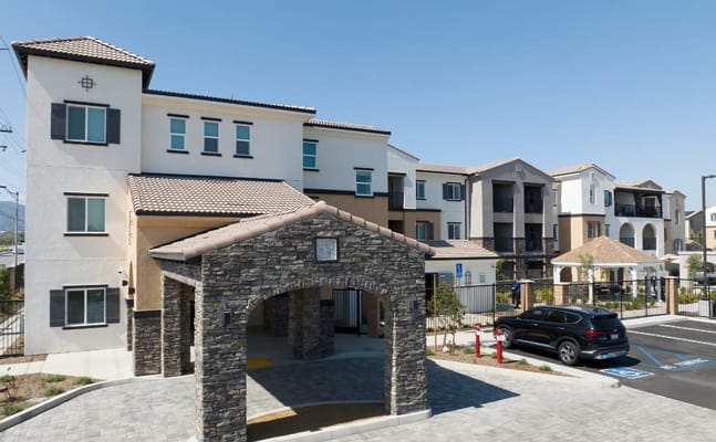 Exterior view of a senior living facility with parking area