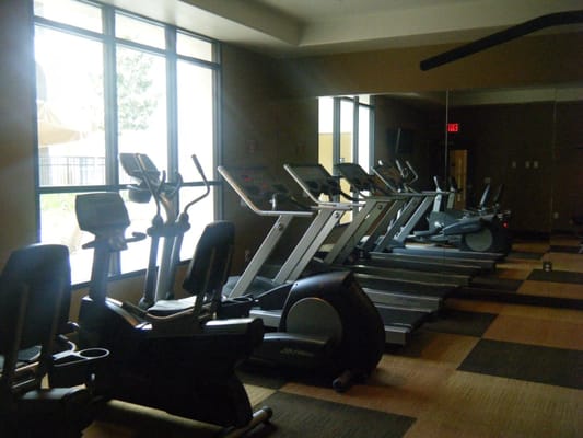 Fitness center with cardio equipment and large windows