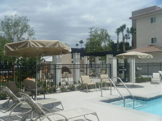 Outdoor pool area with seating and umbrellas