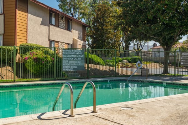 Outdoor swimming pool area surrounded by greenery