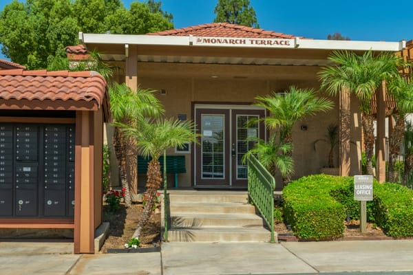 Entrance of Monarch Terrace Apartment Homes with palm trees
