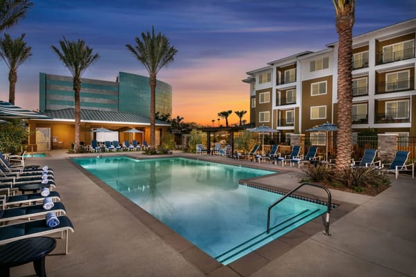 Resort-style pool area surrounded by palm trees