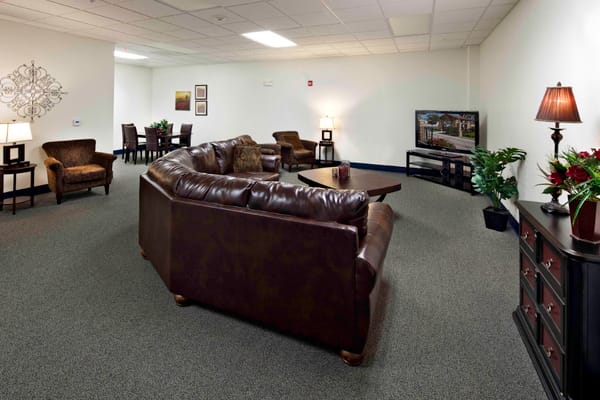 Common area with seating and TV in a senior living facility