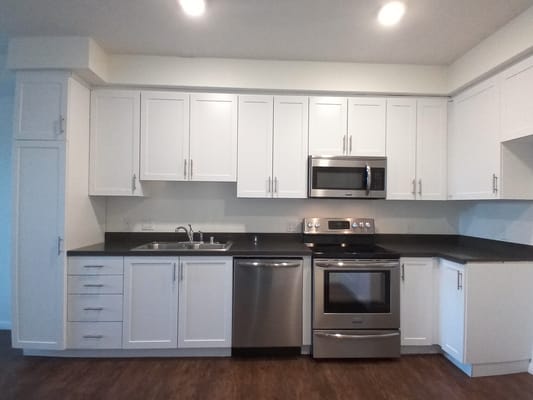 Spacious kitchen with stainless steel appliances and white cabinets