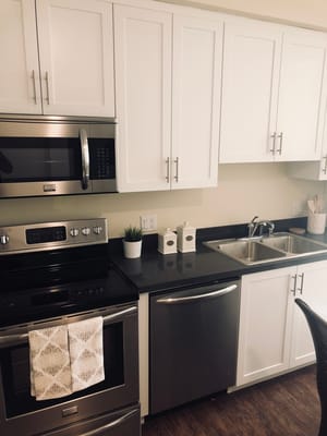 Contemporary kitchen with stainless steel appliances and white cabinetry.