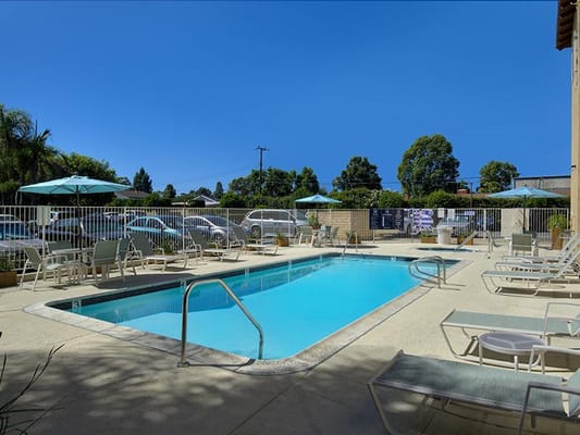 Outdoor pool area with lounge chairs and umbrellas