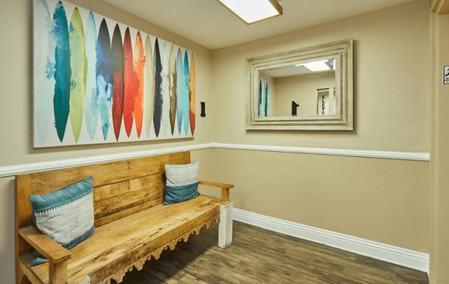 A welcoming interior hallway with a bench and wall art