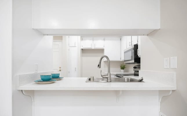 Modern kitchen area with white cabinets