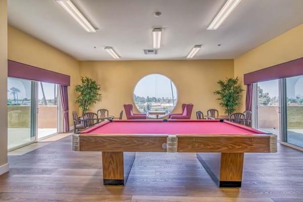 Interior view of the billiards room with a pool table and seating area.