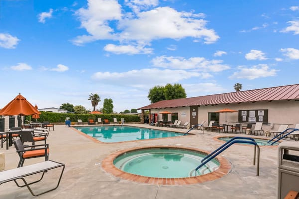 Outdoor pool area with seating and umbrellas