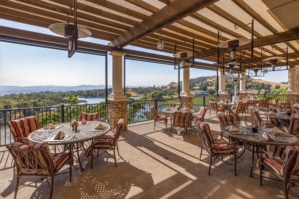 Outdoor dining area with tables and scenic hillside view