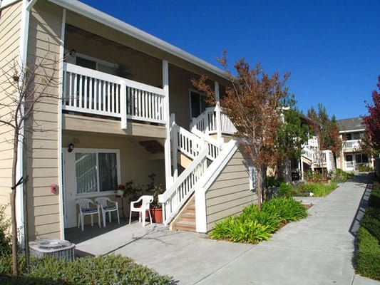 Two-story apartment building with stairs and garden area