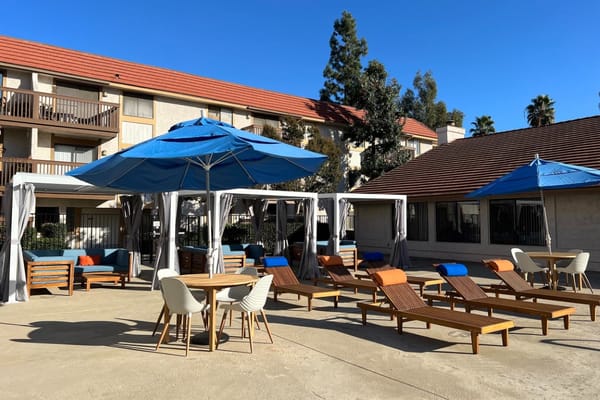 Outdoor pool area with lounge chairs and shaded seating