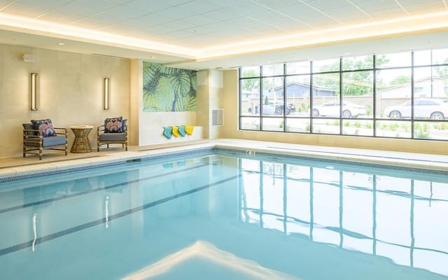 Indoor pool area with seating and large windows