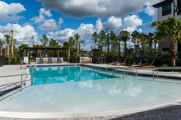 Outdoor pool area with lounge chairs and trees