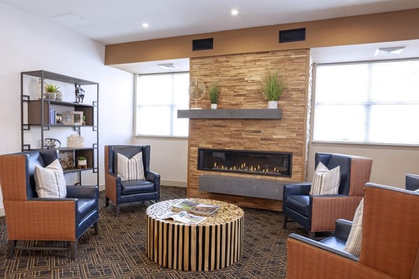 A cozy common area with comfortable seating and a fireplace