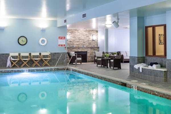 Indoor pool area with seating and lounge space