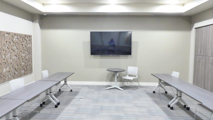 Interior view of a meeting room with tables and a TV