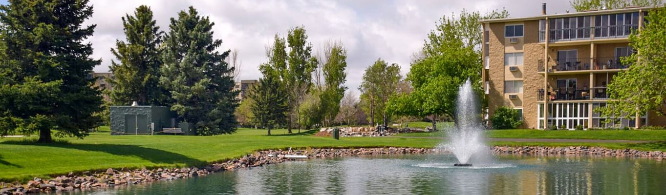 View of landscaped garden and building near a pond