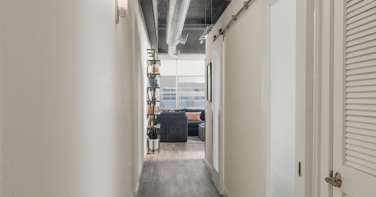 Bright hallway leading to a common area with lounge furniture