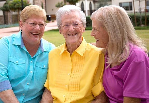 Three residents enjoying time outdoors in a garden