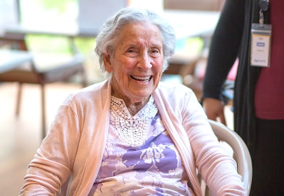 Elderly woman smiling in a facility common area