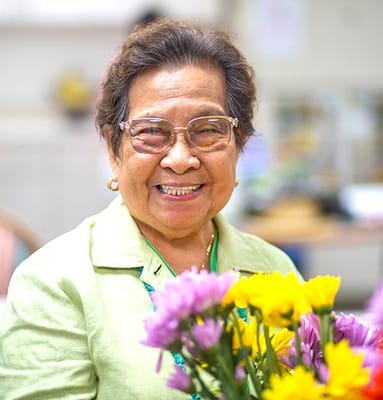 Smiling resident holding a bouquet of flowers