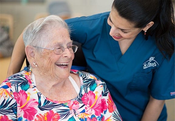 Staff member interacting with a smiling resident