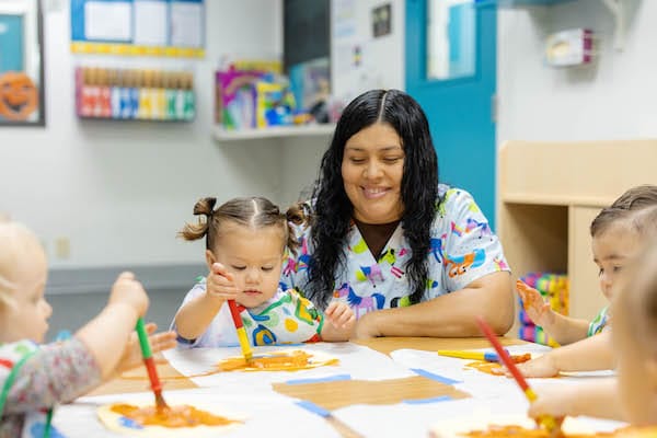 Caregiver and children engaged in an art activity