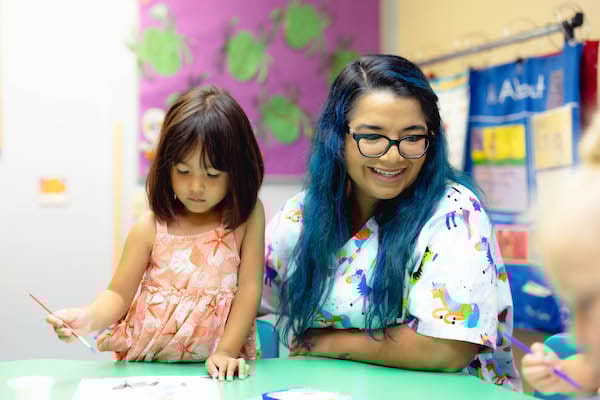 Staff member engaging with a child in an activity area