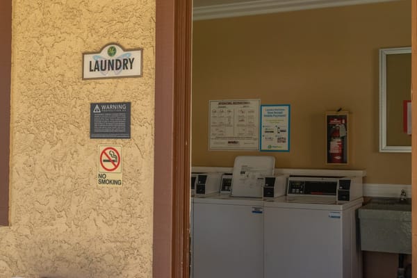Laundry room with washing machines and safety signs